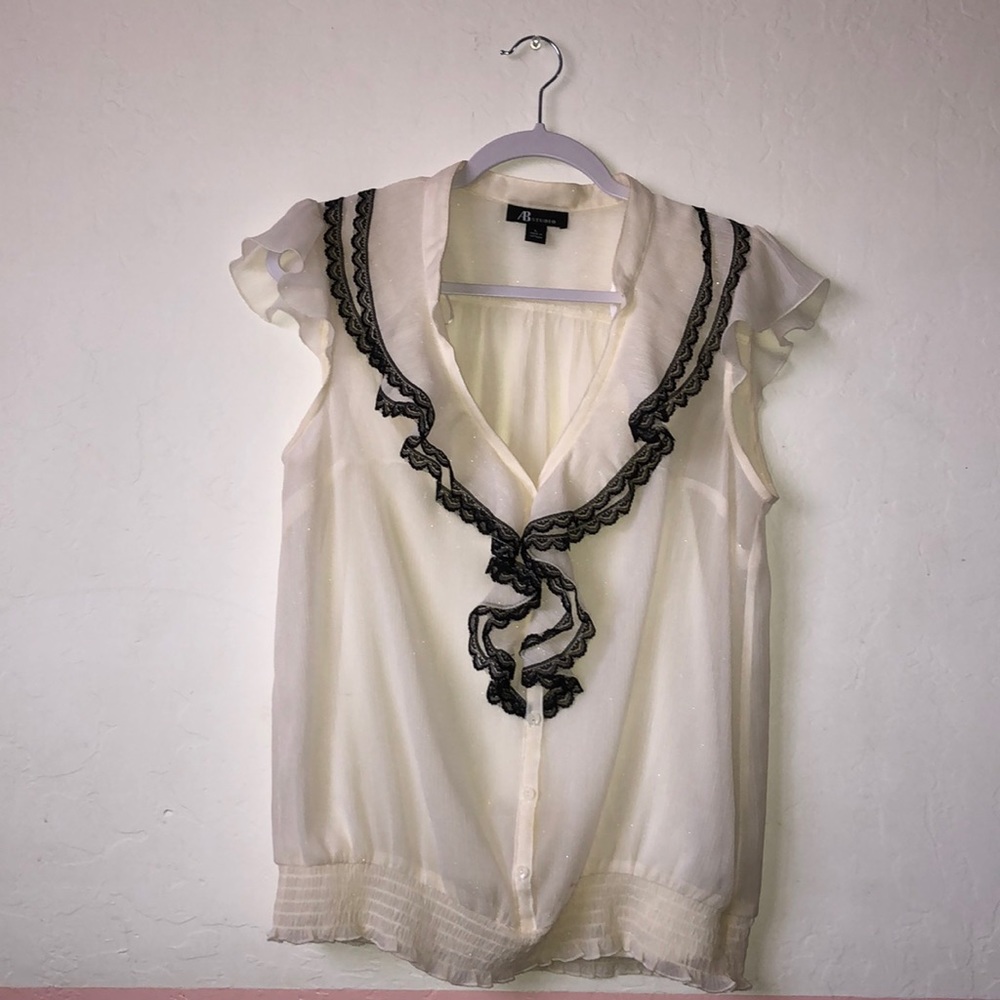Off-white blouse with black lacy ruffles V-neck.